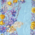Liberty silk scarf with a light blue background and a vibrant floral design