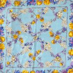 Liberty silk scarf with a light blue background and a vibrant floral design