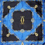 Cartier Silk scarf in a blue, black and gold design with the logo in the centre