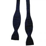 Silk self tie bow tie with a navy blue background and a small white dot design