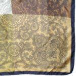 Silk pocket square with a black border and a design in brown, light and nd dark gold