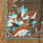 Brown silk scarf with a central design in shades of brown and turquoise blue