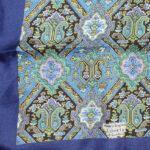 Liberty of London silk scarf with a dark blue border and a detailed central design in b