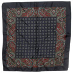 Dark blue background silk pocket square with a red green and white paisley border and a small central design