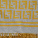 Large grey and yellow soft wool scarf with a design of the Fendi logo repeated.