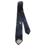 Liberty of London hand printed narrow silk tie with a blue background and a design in dark blue, red and yellow