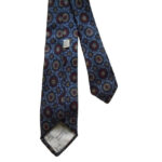 Liberty of London hand printed narrow silk tie with a blue background and a design in dark blue, red and yellow