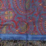 Long silk evening scrf with a blue background and border and a red, yellow and green design