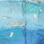 Vera long silk scarf with a blue background and a design of fishnig boats